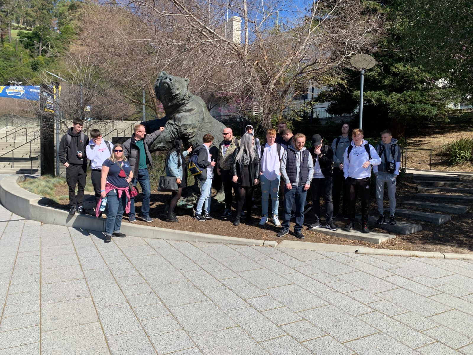 A group of young IVOLO participants and their leaders during an international mobility trip, standing together outdoors on a university campus